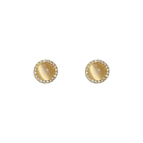Gold oval earrings with a central gemstone on a white background