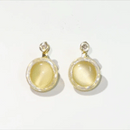 Gold earrings with yellow gemstones on a white background