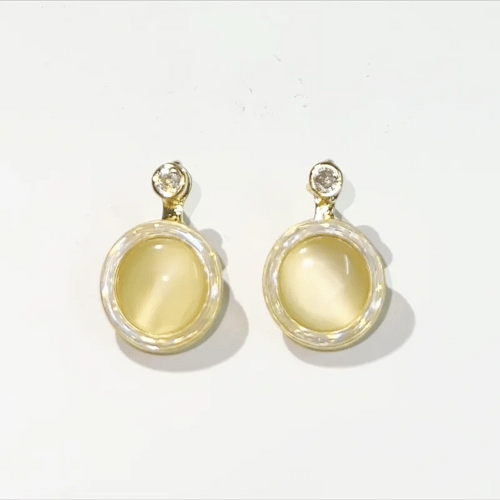 Gold earrings with yellow gemstones on a white background