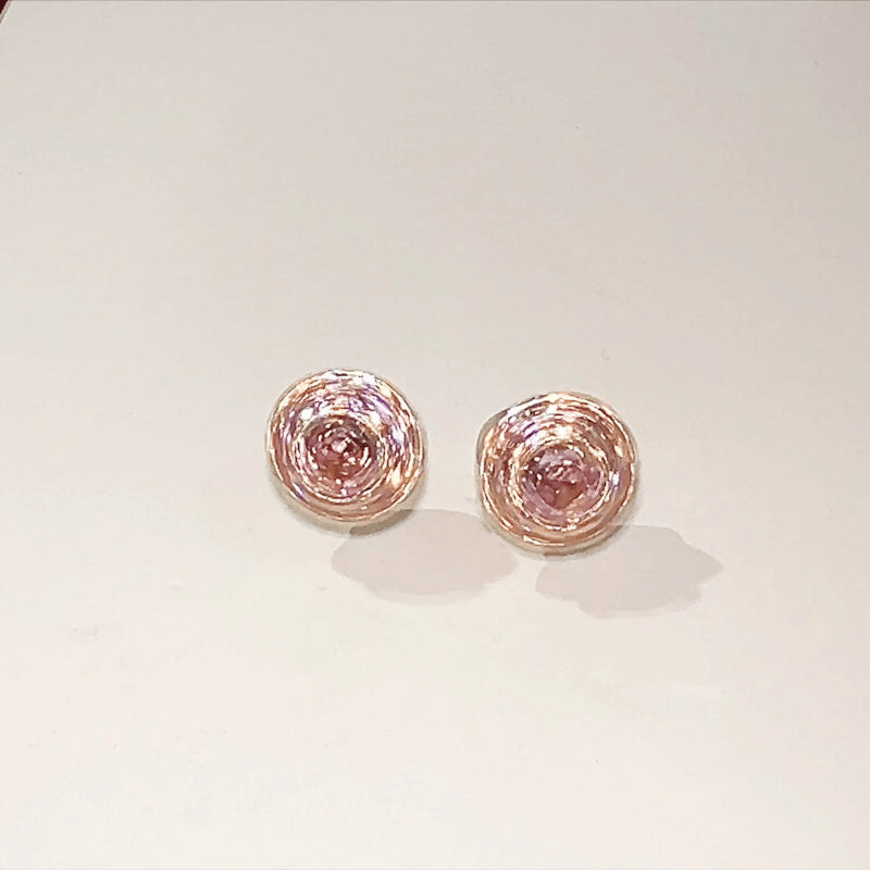 Pair of pink gemstone earrings on a light gray background