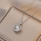 Silver necklace with a pendant on a beige surface