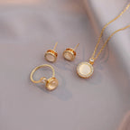 Gold jewelry set with round stones on a soft gray background