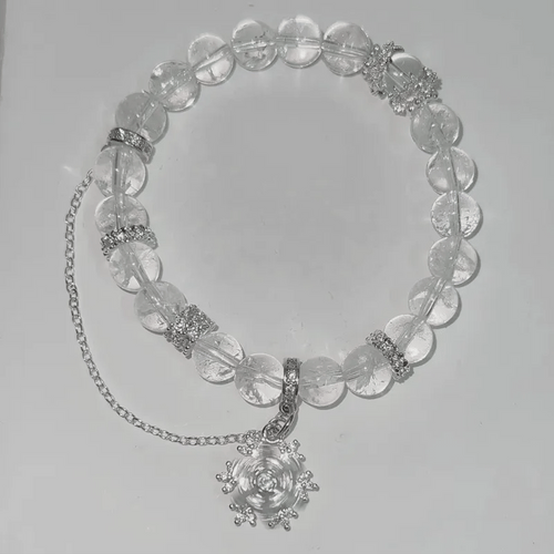 Necklace with clear beads and silver chain on a light gray background
