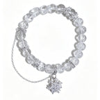 A clear crystal beaded bracelet with silver-toned chain and snowflake charms, displayed on a clean white background.