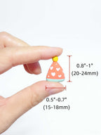 A hand holding a small decorative party hat charm with red dimension lines and text showing its size as 0.8"-1" (20-24mm) tall and 0.