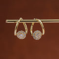 Gold earrings with gemstones on a brown background