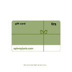 A $75 gift card from SpinnyLuck, featuring an olive green design with a white bottom section, a gift box graphic, and the text 'spinnyluck.com' on a white background.