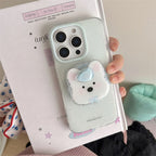 Phone case with a cute design held by a hand on a book