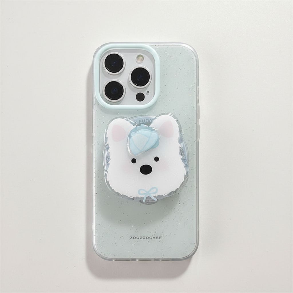A clear speckled phone case with a 3D white bear pop socket featuring a light blue bow, shown on a light gray background.