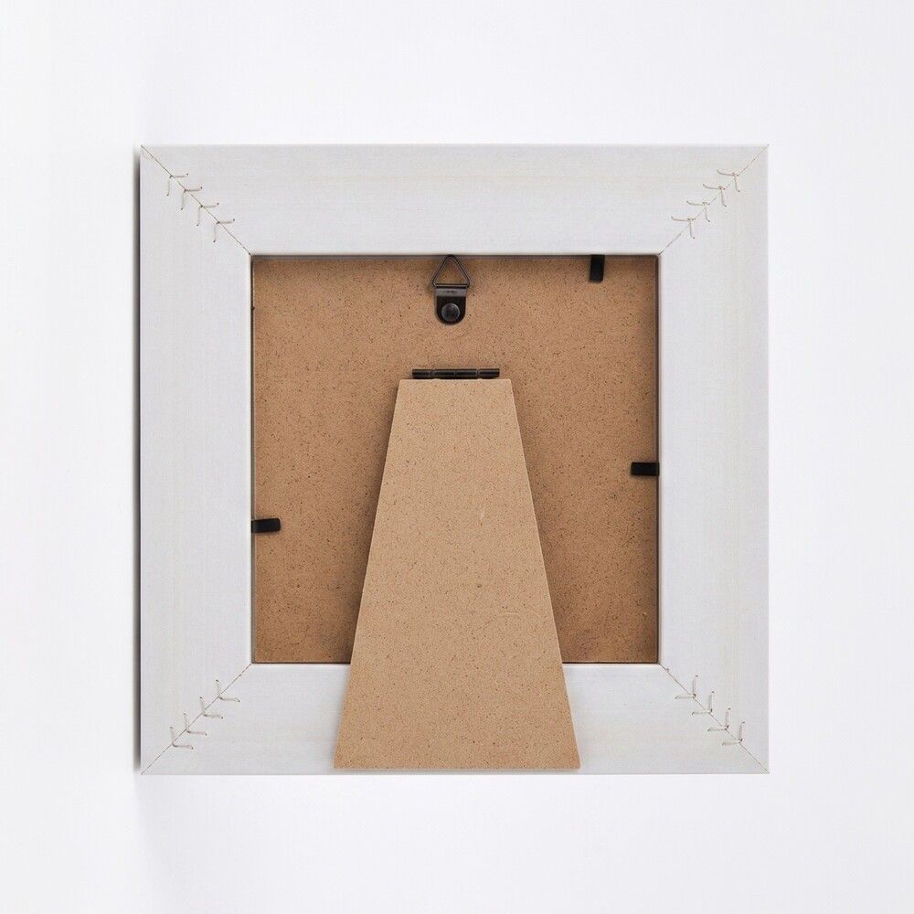 The back of a square picture frame in white, showing the brown cardboard backing and mounting hardware against a white background.