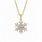 Gold necklace with a snowflake pendant on a white surface