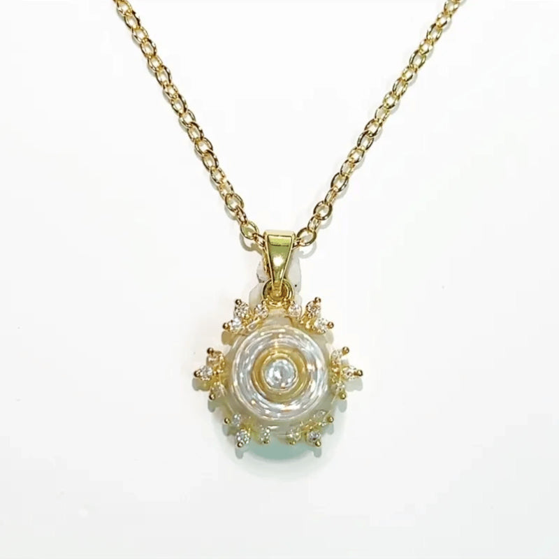 Gold necklace with a decorative pendant on a white background