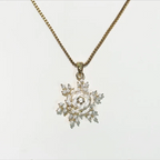 Gold necklace with a star-shaped pendant on a light gray background