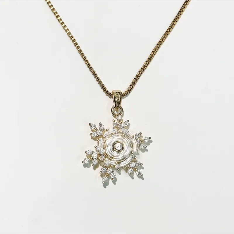 Gold necklace with a star-shaped pendant on a light gray background
