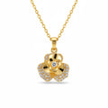 A gold flower pendant necklace on a delicate gold chain, featuring a central clear gemstone surrounded by small pavé-set clear stones, shown against a plain white background.