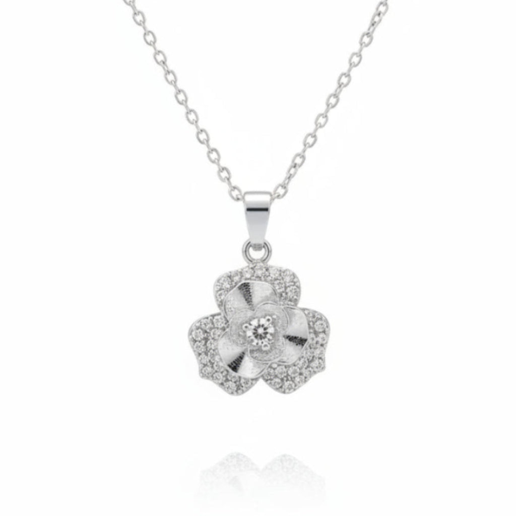 A silver-tone flower pendant necklace with a central clear gemstone and small pavé-set stones, suspended on a delicate chain against a white background.