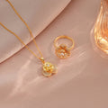 Gold necklace and ring on a beige fabric background