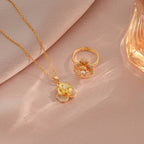 Gold necklace and ring on a beige fabric background