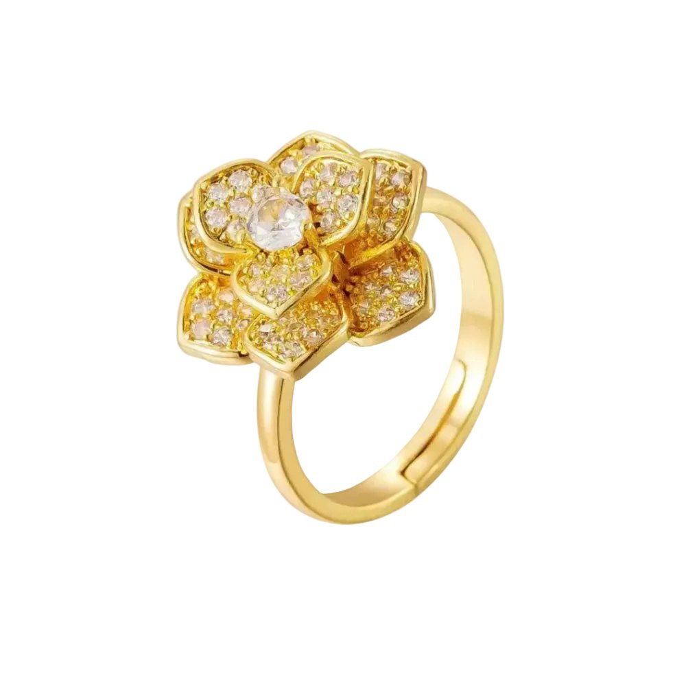 A gold flower ring with a central clear gemstone and small clear stones in the petals, shown on a plain white background.
