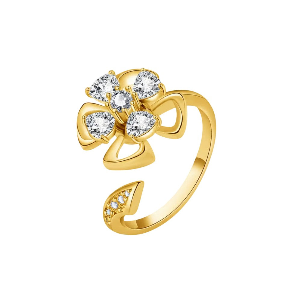 A gold open-band ring featuring a flower-like cluster of clear gemstones at the top and a small line of clear stones on the lower band, shown on a plain white background.