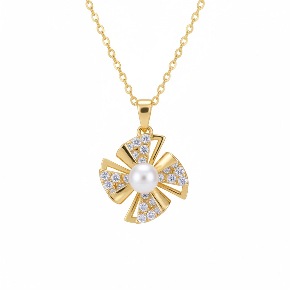Gold necklace with a pendant featuring a pearl and diamonds on a white background