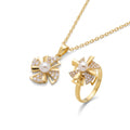 Gold-tone jewelry set featuring a pendant necklace and matching ring, both with a fan-shaped design paved with small clear stones and a central white pearl, shown on a white background.