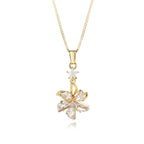 Gold necklace with a star and leaf-shaped pendant on a white background