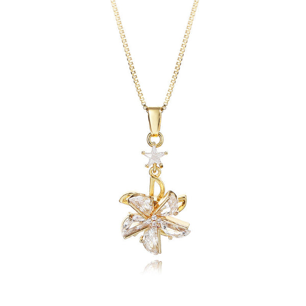 Gold necklace with a star and leaf-shaped pendant on a white background