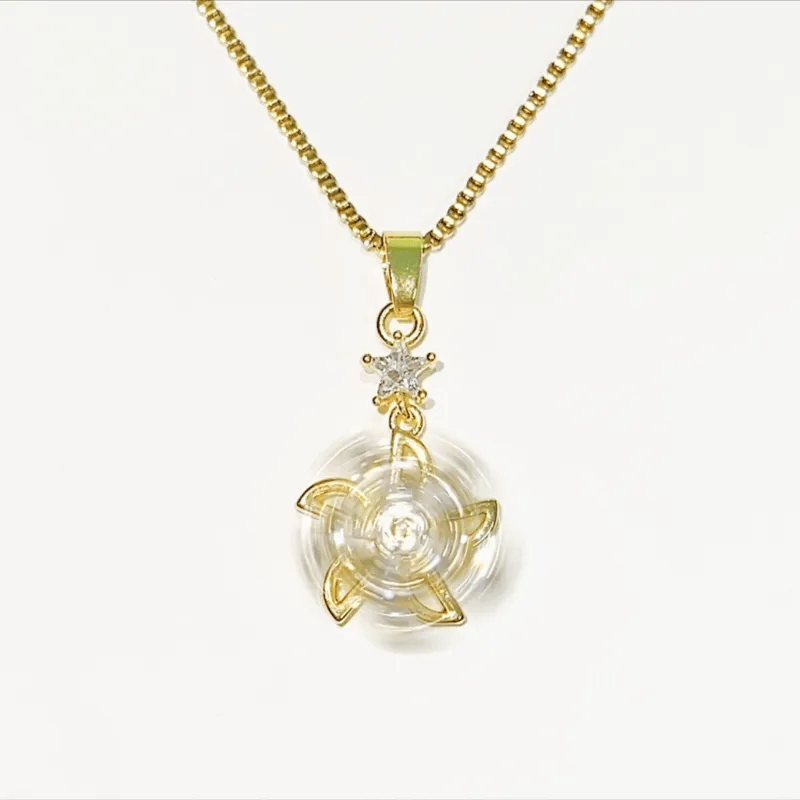 A gold chain necklace with a clear circular pendant featuring a gold four-petal design and a small clear gemstone star accent above it, shown on a plain white background.