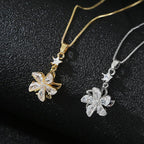 Two floral pendant necklaces, one gold and one silver, on a black background.