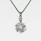 A silver-tone chain necklace with a clear circular pendant featuring a central starburst or ninja-star design, shown on a plain light gray background.
