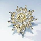 A gold-toned snowflake-shaped ring embellished with clear marquise and round crystals, photographed on a clean white background.